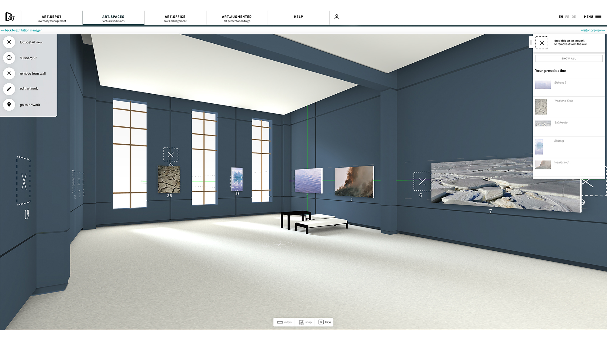 The image shows the user interface of a virtual exhibition room with dark blue wall paint and two large windows. There are already some pictures hanging on the walls, photographs of withered soil, forest fires, melted icebergs. A picture is being positioned, supported by green measure lines.