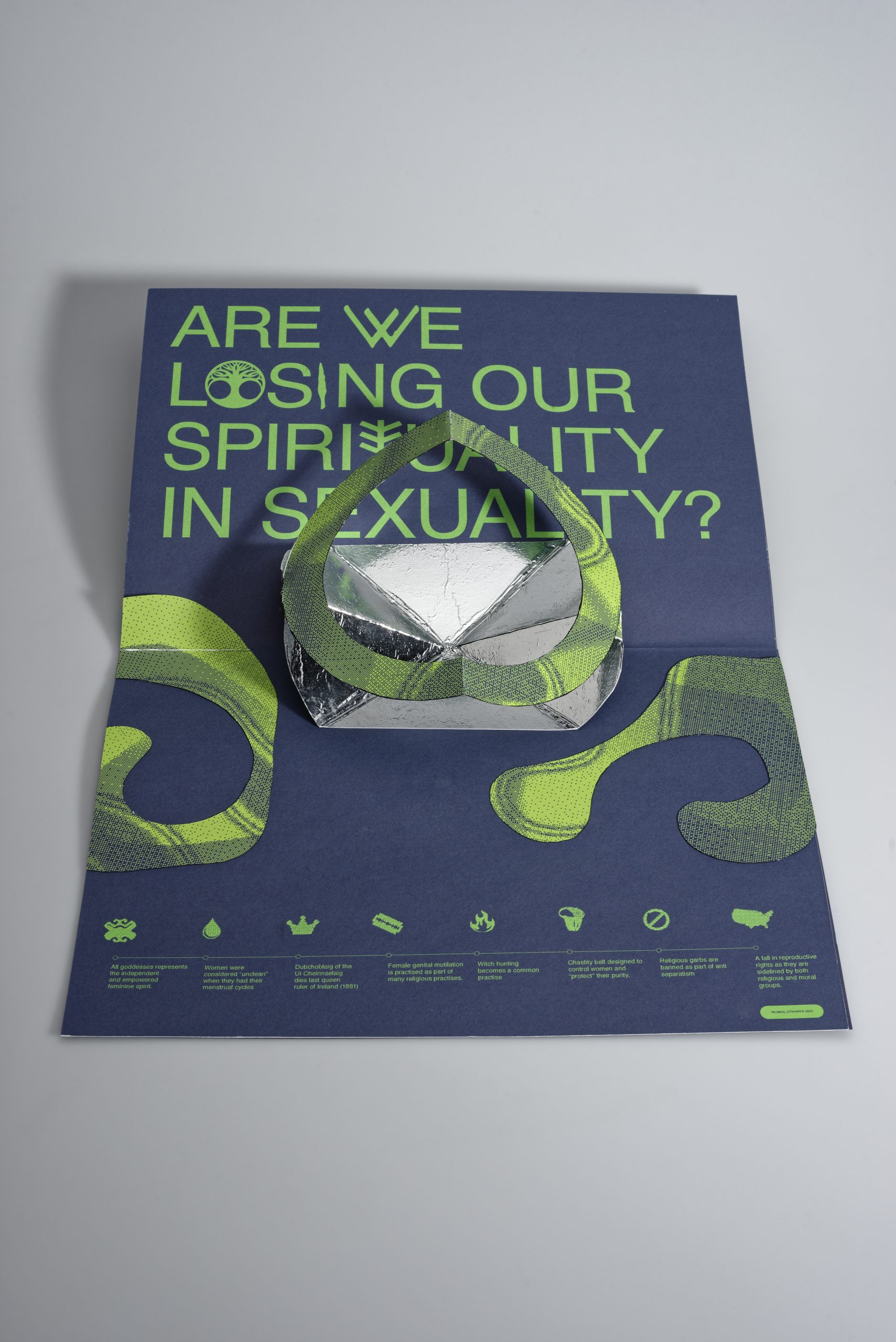 The Enriched Reality scanning pop-up flap contains an abstract volumetric composition that unfolds into a 3D shape. Next to it is the inscription ‘Are we losing our spirituality in sexuality?’ The whole composition is complemented by an audio-video animation via AR, which can be viewed on a mobile phone or tablet screen. 