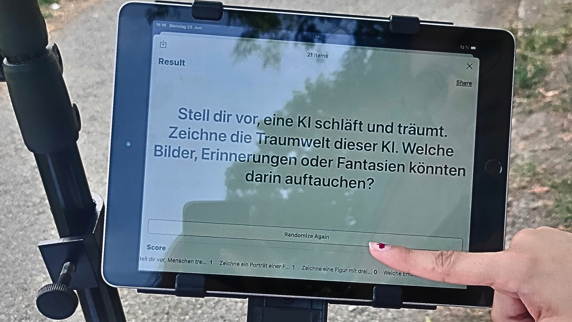 Ein Foto eines Tablets mit einer Frage bzw. Aufgabe für die teilnehmenden Personen. Ein Zeigefinger tippt auf den Bildschirm.